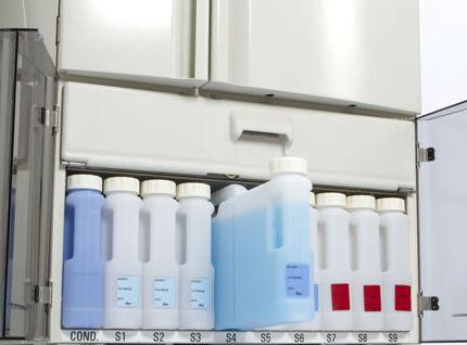 Each of the nine system bottles in the reagent cabinet is labeled to indicate the reagent. The bottle labels are solvent resistant.