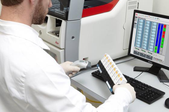 Lab technician loading slides on a Leica BOND RXm staining system